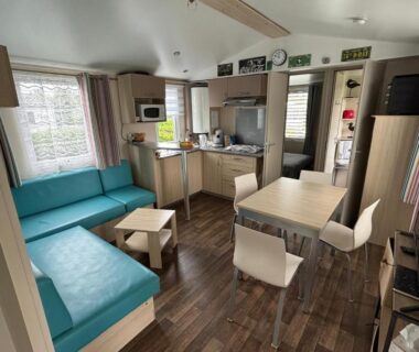 Intérieur salon et kitchenette avec banquette et coin repas de l'Omaha beach mobilhome