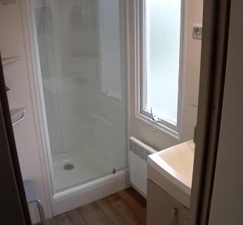 Salle de bain avec cabine de douche et fenêtre dans l'Omaha beach mobilhome
