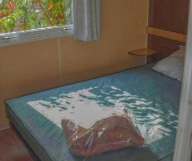 Chambre avec lit et fenêtre dans le mobil-home PARADIS-ZEN