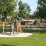Aire de jeux dans pelouse ombragée au Paradis Des Dombes