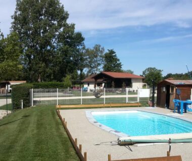 Piscine extérieure et pelouse au camping Paradis Des Dombes