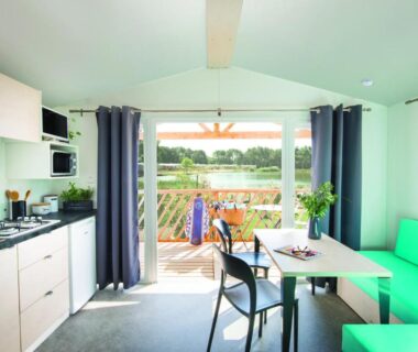 Séjour avec kitchenette et terrasse donnant sur la piscine au Paradis Des Dombes