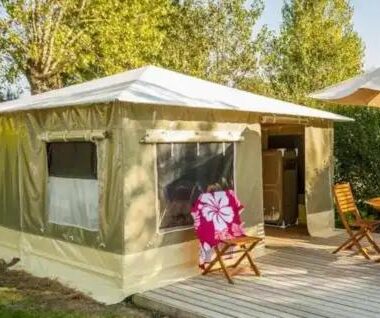 Terrasse en bois avec tente lodge et chaises au camping Paradis Des Dombes