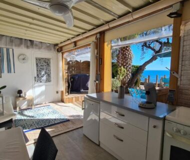 Intérieur ouvert sur terrasse et mer du Paradis bleu et île d'or