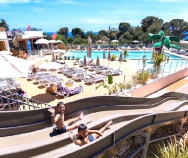 Piscine extérieure avec toboggans et transats au Paradis bleu et ile d'or