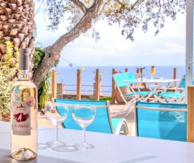 Terrasse avec bouteille et verres face à la mer au camping Paradis bleu et ile d'or