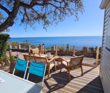 Terrasse en bois avec chaises longues et vue mer au camping Paradis bleu et ile d'or