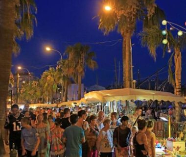 Allée de stands et guirlandes sous palmiers au camping Paradis bleu et ile d'or