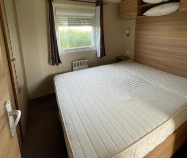 Chambre avec lit double et fenêtre du bungalow Parc Résidentiel La Listra