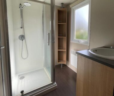 Salle de bain avec cabine de douche et lavabo du bungalow Parc Résidentiel La Listra