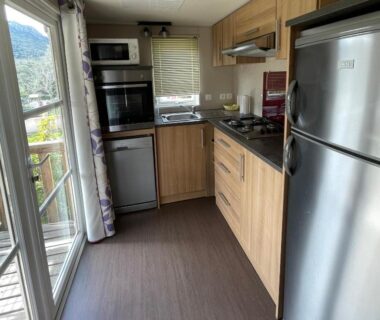 Cuisine équipée avec réfrigérateur et four donnant sur balcon du Parc Résidentiel La Listra - Bungalow