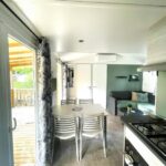 Intérieur avec coin repas kitchenette et baie vitrée donnant sur terrasse dans la Parenthèse nature au Cap Ferret