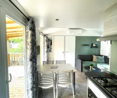 Intérieur avec coin repas kitchenette et baie vitrée donnant sur terrasse dans la Parenthèse nature au Cap Ferret