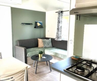 Intérieur avec coin salon et kitchenette du mobil-home Parenthèse nature au Cap Ferret