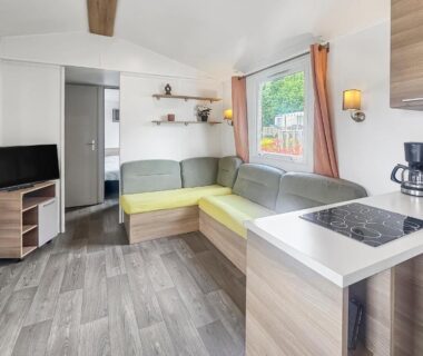 Intérieur avec coin salon et kitchenette dans le mobil home Pause à Litteau
