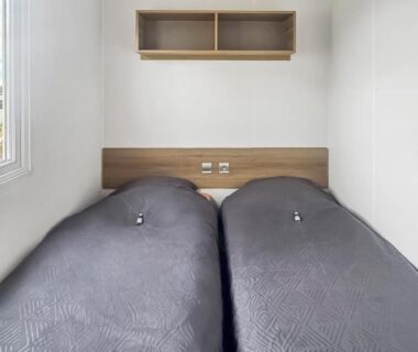 Chambre avec deux lits simples et fenêtre donnant sur l'extérieur au camping Pause à Litteau