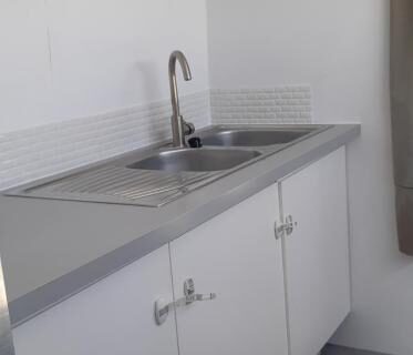 Intérieur kitchenette avec évier et horloge dans le bus aménagé Pépère