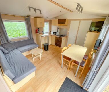 Intérieur de mobil-home avec coin salon et kitchenette au Petit Rio
