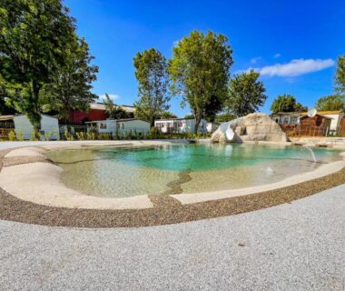 Piscine lagon avec rochers et plage autour au camping Petit Rio