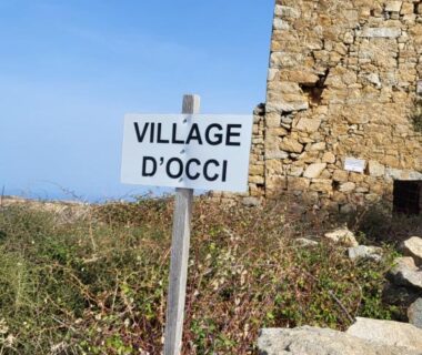 Site avec panneau Village d'Occi et ruine au camping Piana
