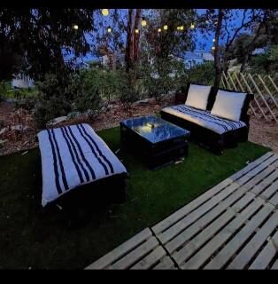 Terrasse extérieure avec banquettes transats et guirlandes lumineuses au camping Piana