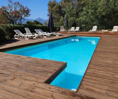 Piscine extérieure sur terrasse en bois avec transats au camping Piana
