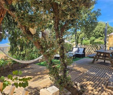 Terrasse en bois avec hamac et transats au camping Piana