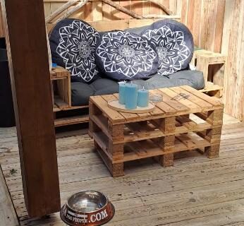 Terrasse couverte avec mobilier en palettes et coussins au camping Plouescat