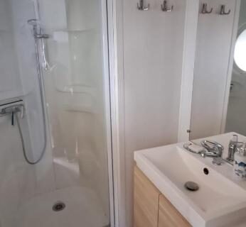 Salle de bains avec cabine de douche et lavabo du camping Plouescat