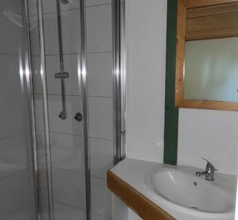 Salle d'eau avec douche cabine et lavabo au Pôle Bellevue
