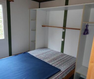 Chambre avec lit double et rangements dans le mobile home du Pôle Bellevue