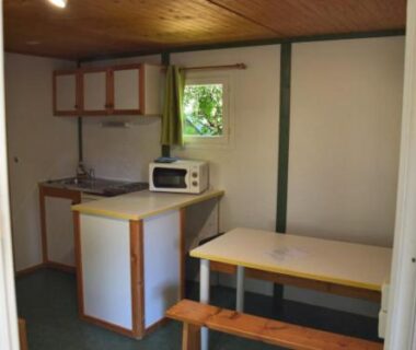 Coin cuisine et table à manger dans le logement du camping Pôle Bellevue
