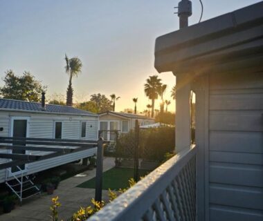 Balcon en bois au coucher de soleil avec palmiers et mobilhomes du Premium Mobilhome Grimaud