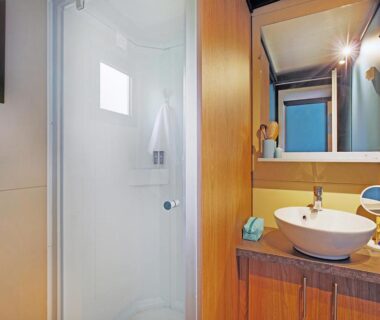Salle de bain avec cabine de douche et lavabo dans le camping RAS L'BOL
