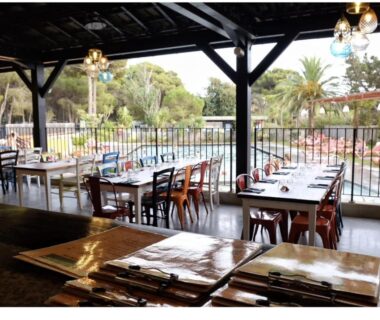 Terrasse couverte avec tables et chaises au camping RAS L'BOL