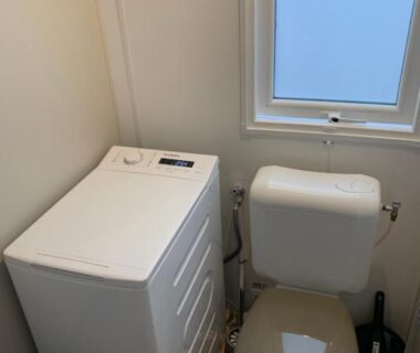Toilettes compactes avec lave-linge à côté de la cuvette au camping RESPIRE