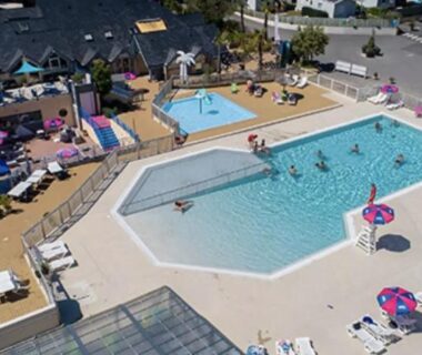 Piscine extérieure avec baigneurs et transats au camping RESPIRE