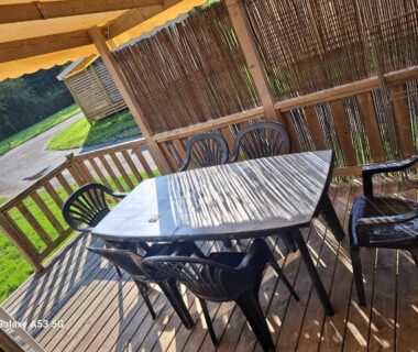 Terrasse en bois avec table et chaises et store banne au RIVA BELLA Lodge 171