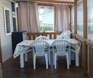 Terrasse couverte avec table et chaises au camping Repos mérité