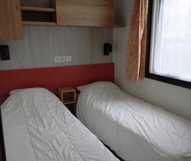 Chambre avec deux lits simples et fenêtre au camping Repos mérité