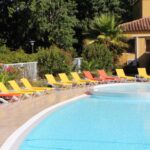 Piscine extérieure bordée de transats à la Résidence Lagrange Vacances - Les Cottages Varois
