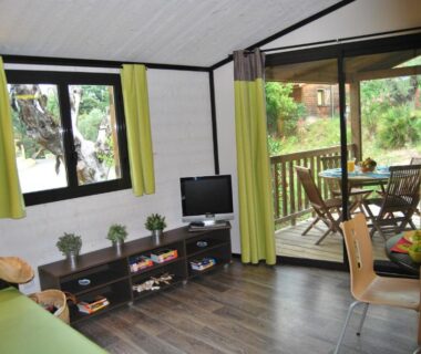 Salon avec terrasse en bois et mobilier extérieur à la Résidence Lagrange Vacances Les Cottages Varois