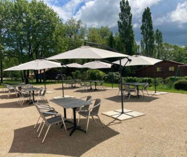 Terrasse extérieure avec parasols et tables à la Résidence les chênes
