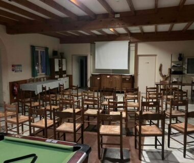 Salle polyvalente avec rangées de chaises écran et billard à la Résidence les chênes