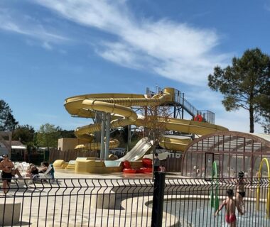 Bassin extérieur avec toboggans aquatiques et pataugeoire au camping Rêves de pins