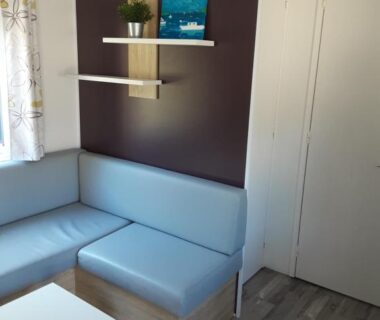 Intérieur coin salon avec banquette et table du mobil-home Riva Bella chez Caraphou