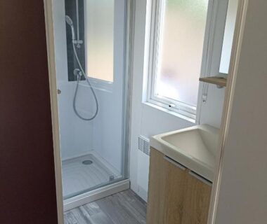 Salle d'eau compacte avec douche et lavabo au Riva Bella chez Caraphou