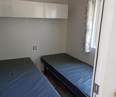 Chambre avec deux lits simples et fenêtre dans le Riva Bella chez Caraphou