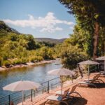 Bord de rivière avec chaises longues au camping Rives d'Arc