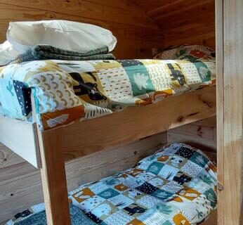 Intérieur en bois avec lits superposés dans la Roulotte Le Coq La Mazille